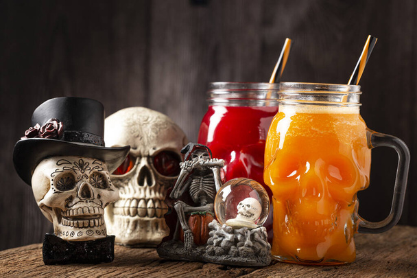 Halloween drankje. Pompoendrank en bloeddrank in schedelglas. - Foto, afbeelding