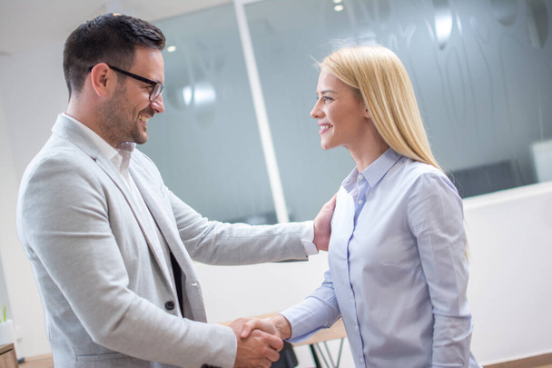 Üzleti nő és férfi kezet rázott sikeres találkozó után az irodában - Fotó, kép