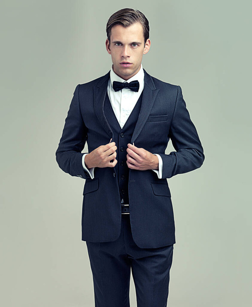 Man, studio and portrait with vintage, suit and fashion for class or luxury retro wealth. Gentleman, tuxedo and spy or agent with confidence, style and serious attitude isolated on white background. - Photo, Image
