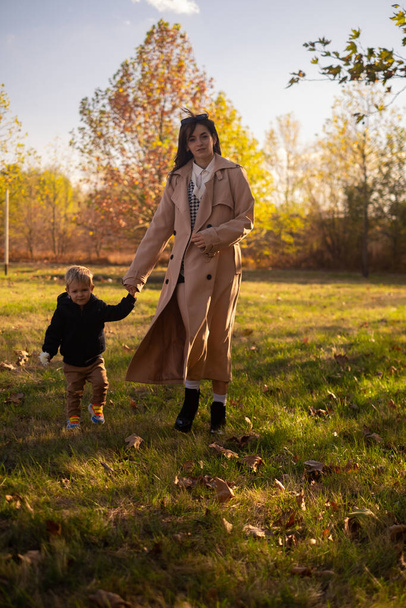 Мать и сын прогуливаются по весеннему парку, наслаждаются семейными выходными, отмечают День матери. - Фото, изображение