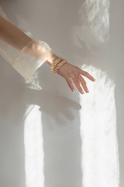 ręce pozujące w słońcu, noszące złote bransoletki - Zdjęcie, obraz