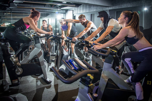 Vzrušení sportovci posilující na cyklistické třídě v tělocvičně - Fotografie, Obrázek