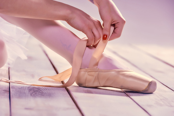 Professional ballerina putting on her ballet shoes. - Foto, Imagen