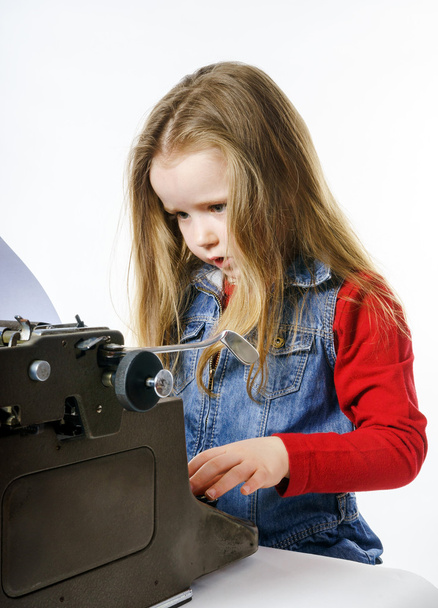Симпатична дівчинка, що друкує на старовинній клавіатурі друкарської машинки
 - Фото, зображення