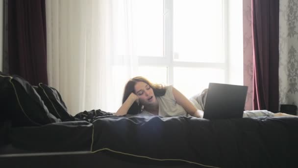 Yatakta yatan ve evde dizüstü bilgisayarla çalışan bir kadın uyuyakalmış. Ağır çekim. Evde çalışmak, yaşam tarzı kavramı - Video, Çekim