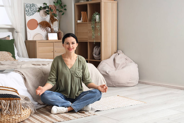 Красивая женщина медитирует в спальне
 - Фото, изображение