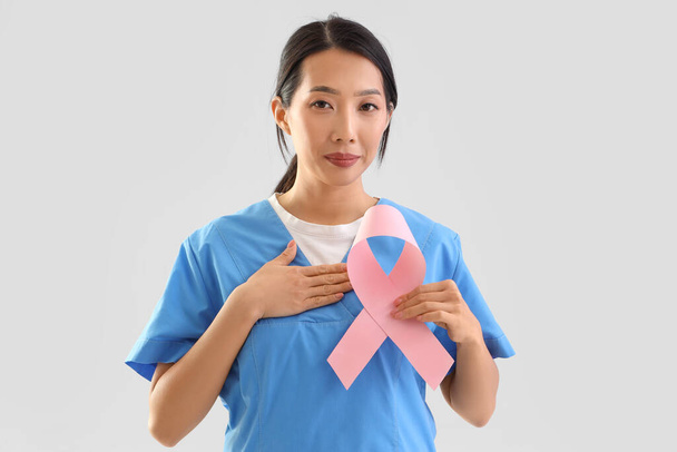 Pembe kurdeleli Asyalı kadın doktor. Göğüs kanseri farkındalığı konsepti - Fotoğraf, Görsel