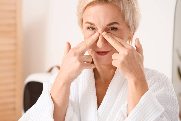 Olgun kadın banyoda yüz geliştirme egzersizi yapıyor, yakın plan. - Fotoğraf, Görsel