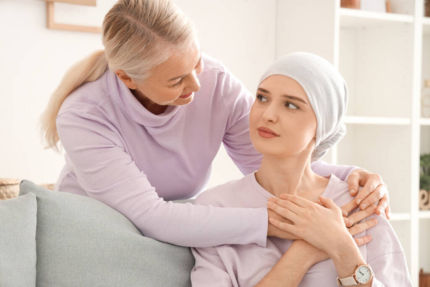Young woman after chemotherapy with her mother hugging at home. Stomach cancer concept - Photo, Image