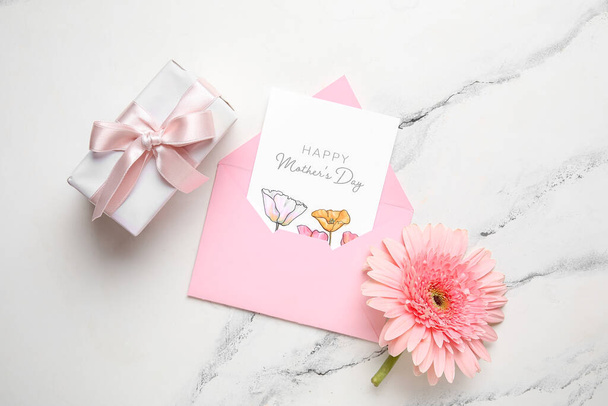 Envelope com cartão postal festivo, caixa de presente e flor em fundo grunge branco. Feliz Dia das Mães - Foto, Imagem