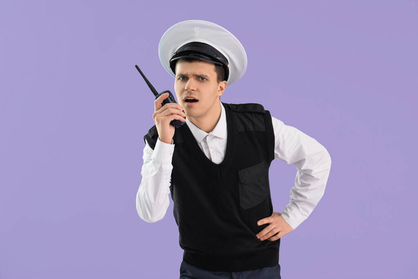 Giovane marinaio con trasmettitore radio su sfondo lilla - Foto, immagini