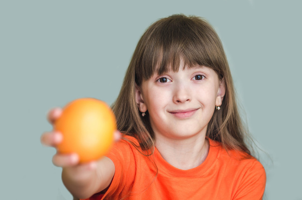 Mädchen reicht orangen ausgestreckten Arm nach vorne. - Foto, Bild
