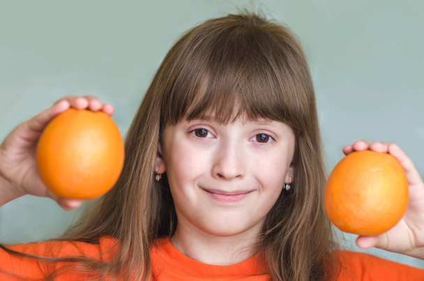 Lány tartja a narancs narancs és mosolyogva - Fotó, kép