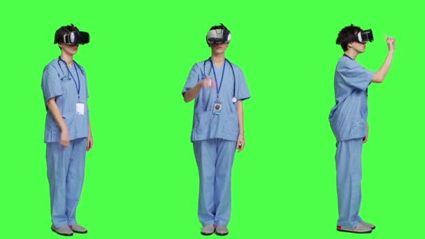Specjalista ds. zdrowia za pomocą zestawu słuchawkowego vr do badania diagnozy pacjenta, stoi na zielonym tle ekranu. Pielęgniarka pracuje ze sztuczną inteligencją, okularami wirtualnej rzeczywistości, trójwymiarowymi. Kamera A. - Materiał filmowy, wideo