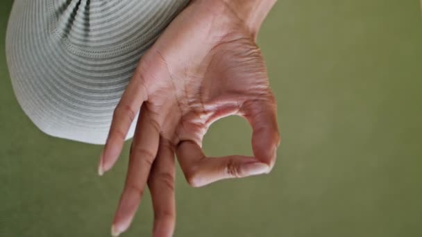 Closeup girl fingers yoga meditation indoor. Unrecognizable woman connecting index thumb finger sitting rubber sport carpet vertical oriented. Sportive lady hands doing gyan mudra gesture at mat.  - Footage, Video