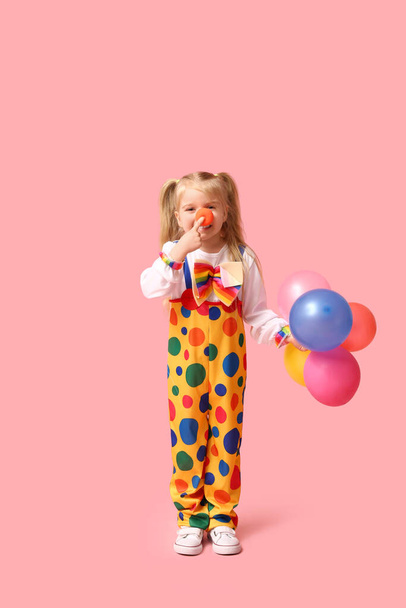 Cute little girl w stroju klauna z balonami na różowym tle - Zdjęcie, obraz