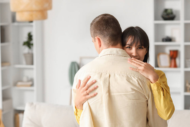 Młoda kobieta przytula męża w domu - Zdjęcie, obraz