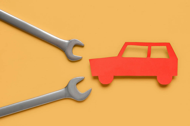 Sarı arka planda anahtarlar ve oyuncak araba, yakın plan. Mekanik kavram - Fotoğraf, Görsel