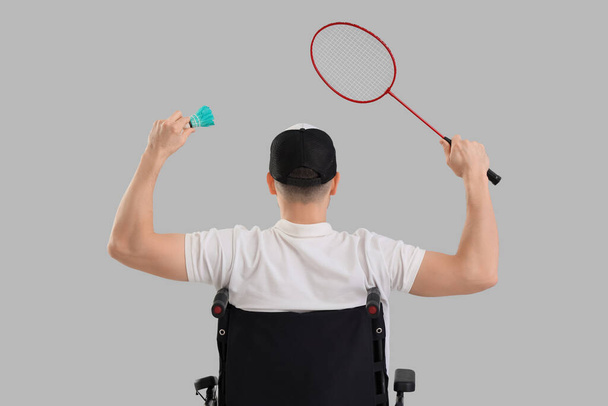 Badminton giocatore in sedia a rotelle con racchetta e volano su sfondo chiaro, vista posteriore - Foto, immagini