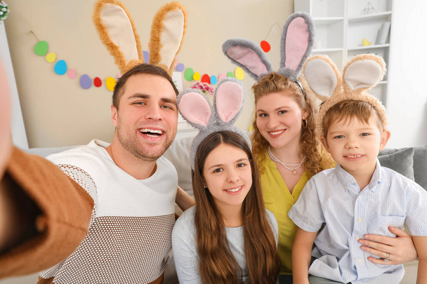 Rodzina z wielkanocnymi uszami króliczka robi selfie w domu - Zdjęcie, obraz