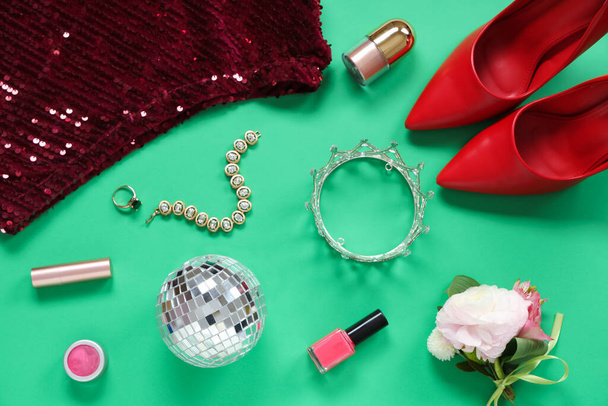 Weiblicher Abschlussball mit Discokugel, Boutonniere und Make-up-Produkten auf grünem Hintergrund - Foto, Bild