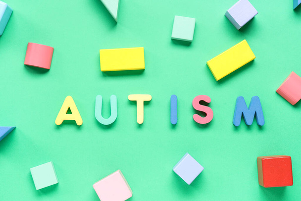 Word AUTISM with colorful blocks on green background - Photo, Image