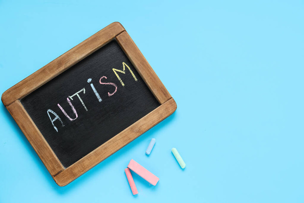 Дошка зі словом AUTISM на синьому фоні. Концепція розладу аутизму - Фото, зображення