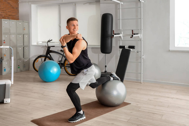 Sporty young man training with fitball at gym - Fotoğraf, Görsel