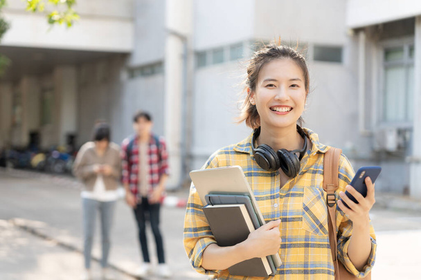 Portrait beautiful Asian woman student. Smile girl happy study. read book in college campus. young female on international Asia University. Education, study, school, learning, exam, continue education - 写真・画像