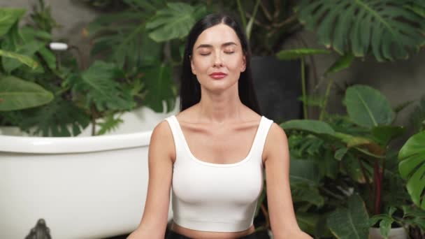 Young woman doing morning yoga and meditation in natural garden with plant leaf, enjoying the solitude and practicing meditative poses. Mindfulness activity and healthy mind lifestyle. Blithe - Footage, Video