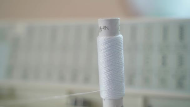 Witte draad in een naaimachine, close-up. De spoel draad draait terwijl de naaimachine draait. Hoge kwaliteit FullHD beeldmateriaal - Video