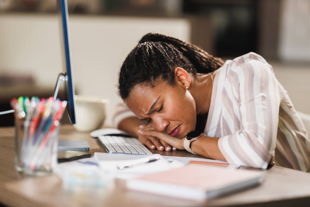 Africano mulher de negócios olhando estressado enquanto trabalhava no computador de seu escritório em casa. - Foto, Imagem