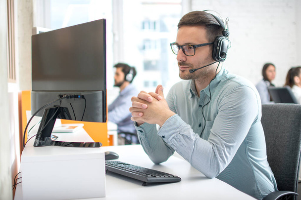 Obsługa klienta operator człowiek ze słuchawkami i mikrofonem słuchanie swojego klienta w call center - Zdjęcie, obraz