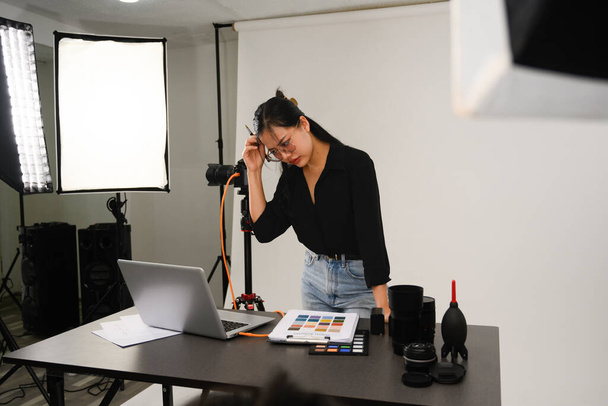 Frustrated female photographer working at her studio. - Photo, Image