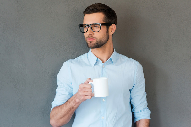 Man in shirt in eyewear holding cup - Фото, зображення