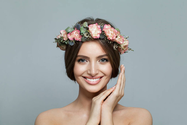 Mooie model vrouw met frisse heldere huid glimlachend op grijze achtergrond. Gezichtsbehandeling, huidverzorging en kosmetologie - Foto, afbeelding