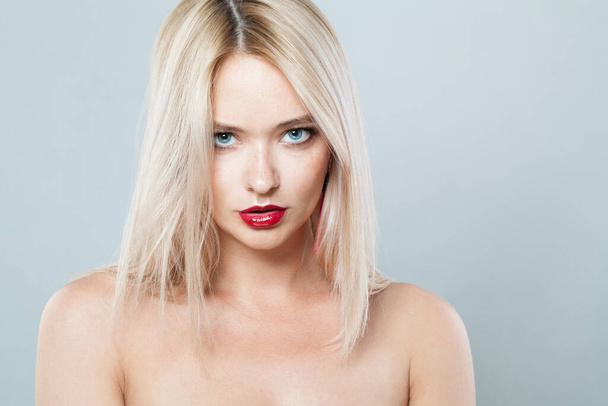 Modèle féminin de mode parfait avec une longue coiffure blonde et une peau fraîche brillante sur fond blanc, portrait en studio  - Photo, image
