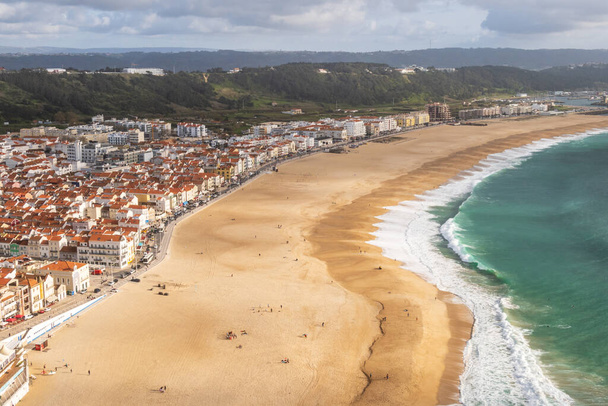 Aerial view over the red rooftops of Nazare, Portugal, down to Nazare Beach and the Atlantic Ocean - Photo, Image