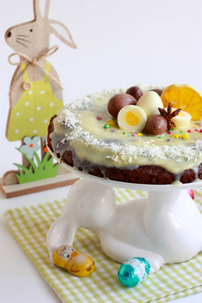 Gâteau de Pâques au chocolat - brownie avec glaçage au chocolat blanc et décoré avec des œufs en chocolat et des frites d'orange - Photo, image