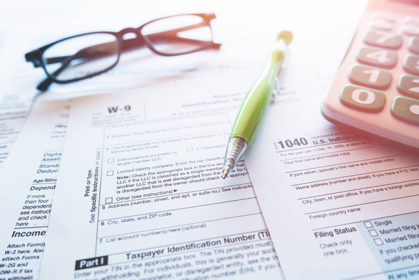 1040 Individuelle Lohnsteuerformulare mit Stift und Brille zum Ausfüllen bereit. Steuersaison - Foto, Bild