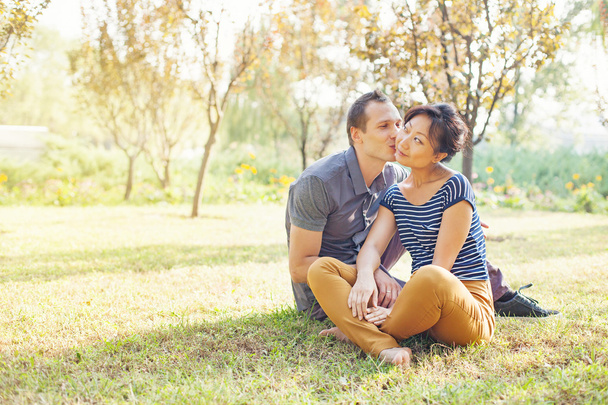 Couple sitting on a grass - Foto, imagen