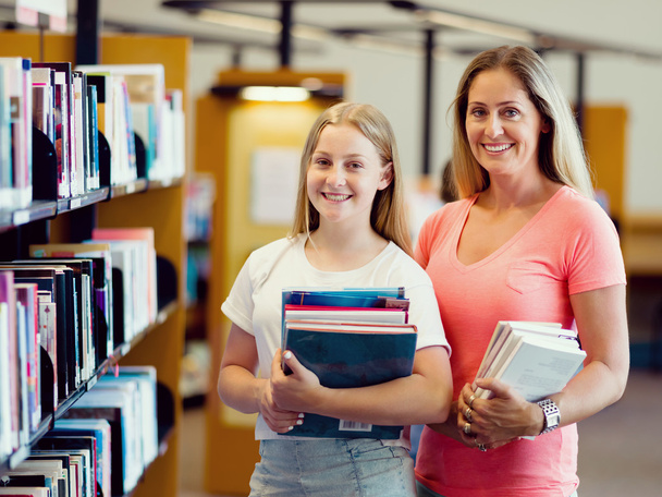 Girl and her mother in library - Foto, Bild