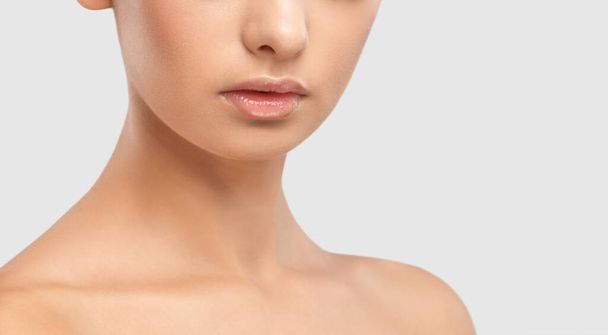 Lippen und Gesicht einer jungen Frau in Großaufnahme. Kosmetische Pflege für Gesicht und Lippen. - Foto, Bild