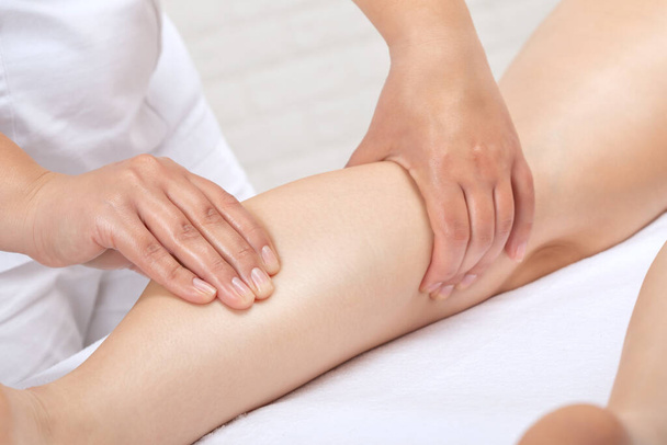 Masseur maakt anti-cellulitis massage van de benen, dijen, heupen en billen in de spa. Overgewicht behandeling, body sculpting.Cosmetologie en massage concept. - Foto, afbeelding
