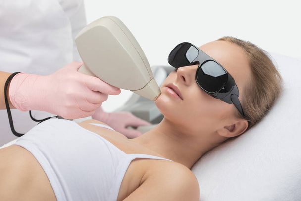 Elos epilatie ontharing procedure op het gezicht van een vrouw. Gezichtsverzorging. Hardware ipl cosmetologie - Foto, afbeelding