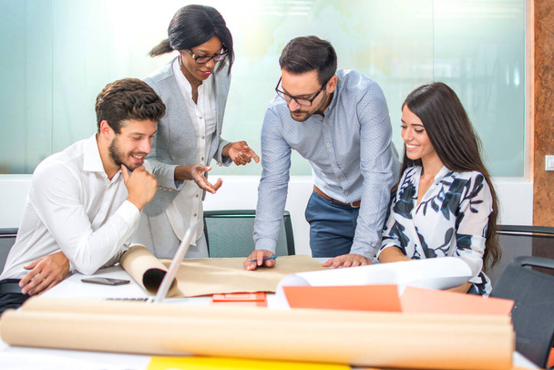 Equipo de emprendedores comunicándose mientras desarrollan una nueva estrategia de negocio en la oficina - Foto, imagen