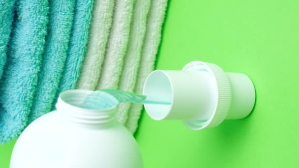 El proceso de verter el detergente líquido ecológico natural de la ropa del gel de la botella en la tapa, brote vertical. - Imágenes, Vídeo