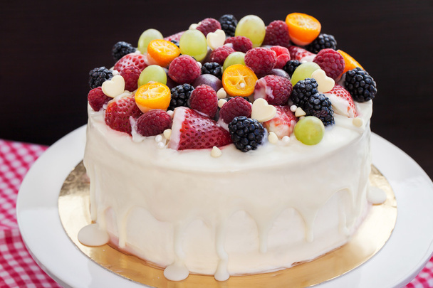 Witte chocolade cake versierd met verse bessen en vruchten - Foto, afbeelding