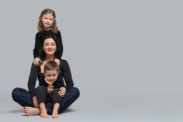 Little children with their mother on grey background. Space for text - Fotoğraf, Görsel