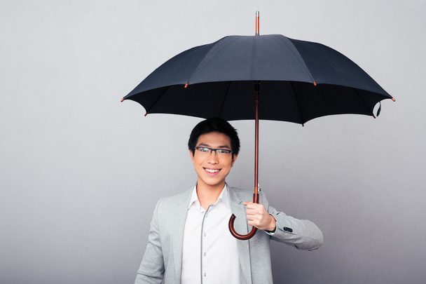 Щасливий бізнесмен стоїть з парасолькою
 - Фото, зображення